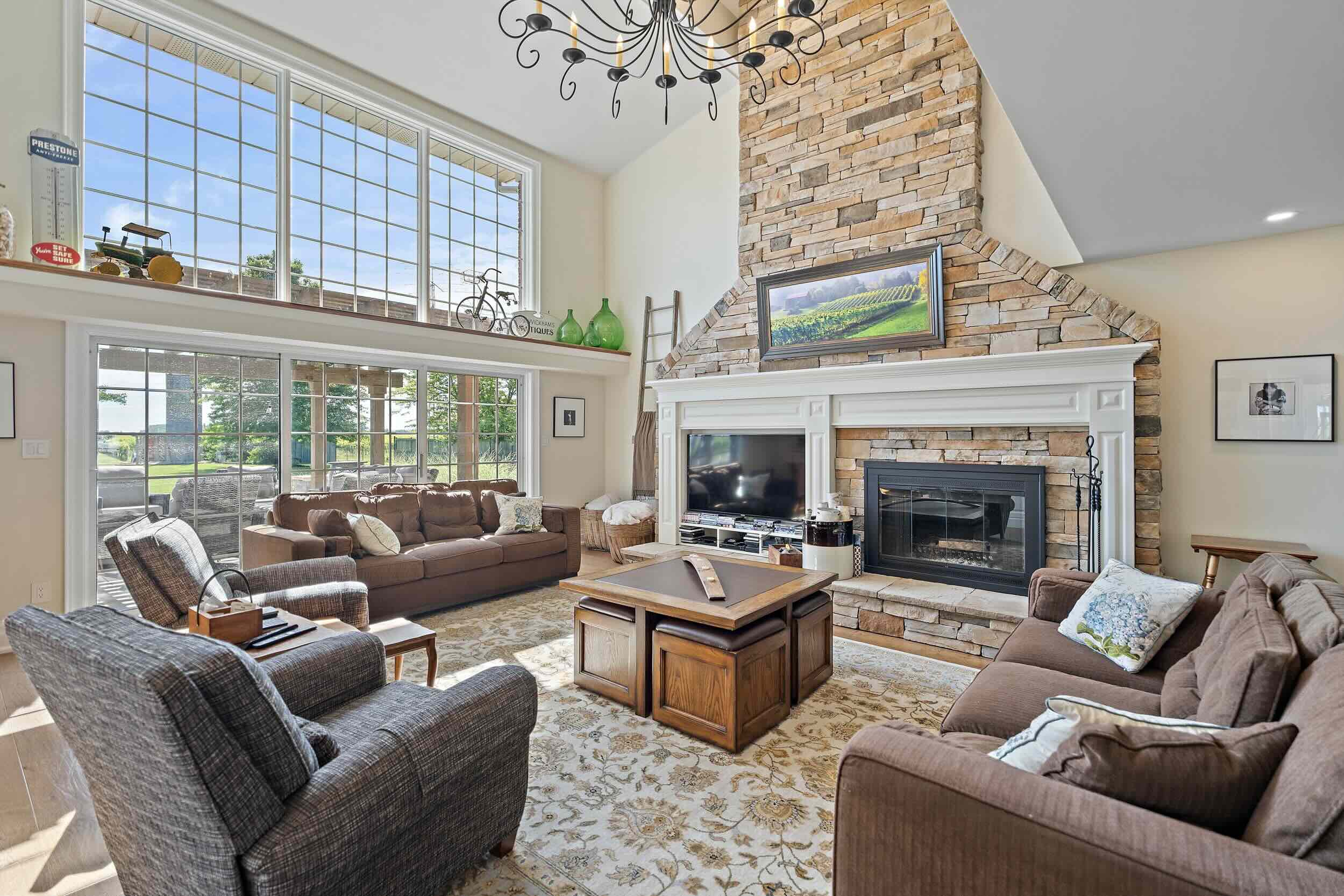The great room sets the tone with 16-foot ceilings and a floor-to-ceiling stone wood-burning fireplace